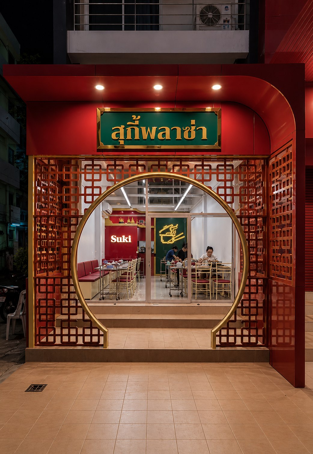 Suki Plaza restaurant storefront with red and gold facade at night